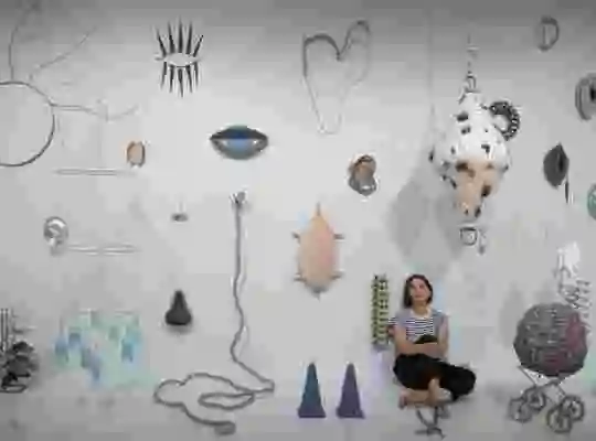 Bildkonstnären Anastasia Savinova sitter i ett rum tillsammans med en massa objekt