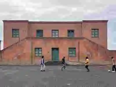 People playing football in front of fascist style building