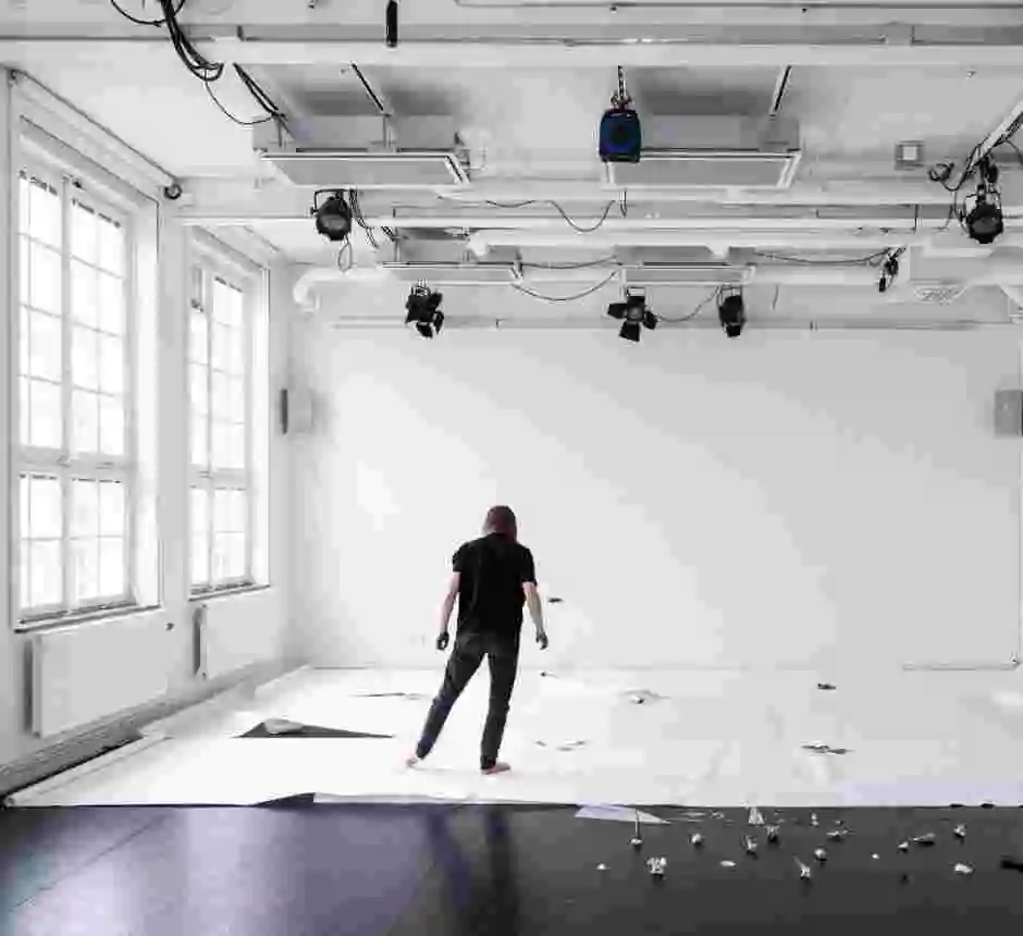 Dansare i installation av papper och objekt i dansstudio