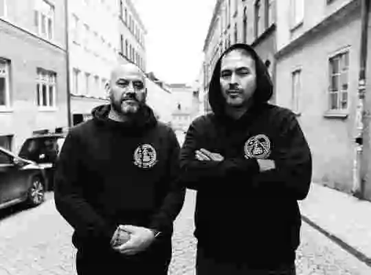 Svartvitt porträtt av två musikproducenter på en gata