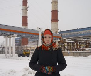 Porträtt av kvinna framför industribyggnad