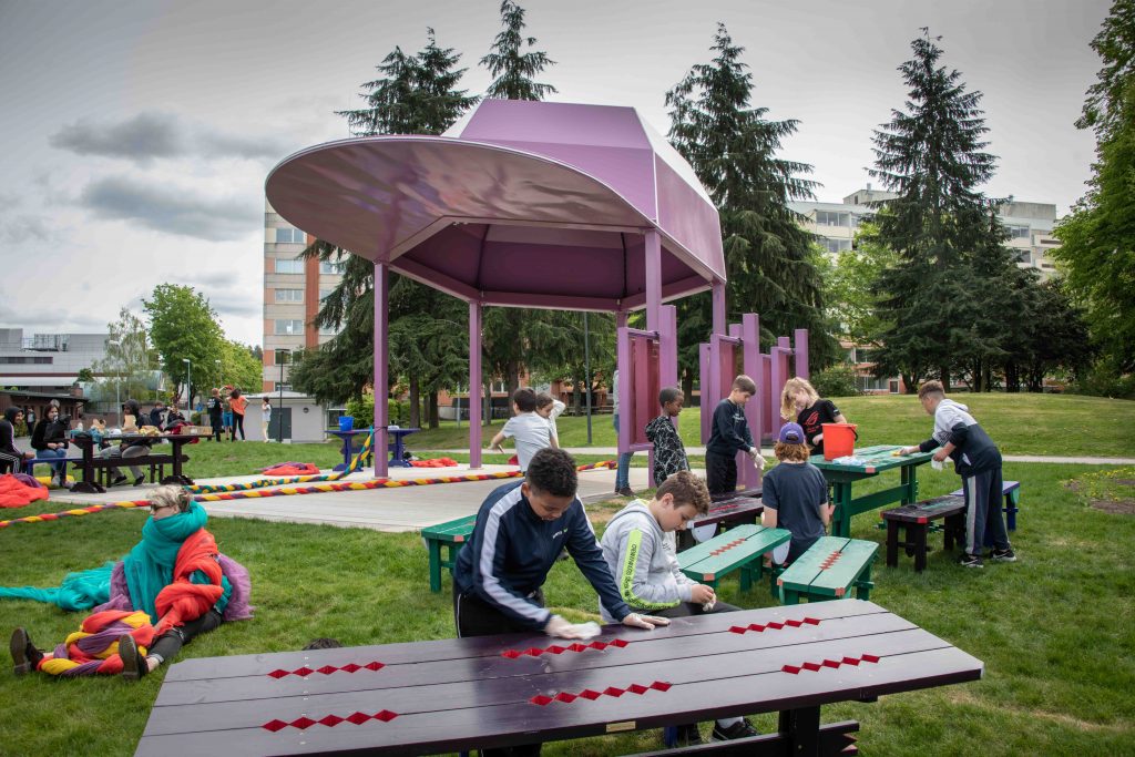 Konstinstallation och paviljong i en park i form av en stor rosa keps 