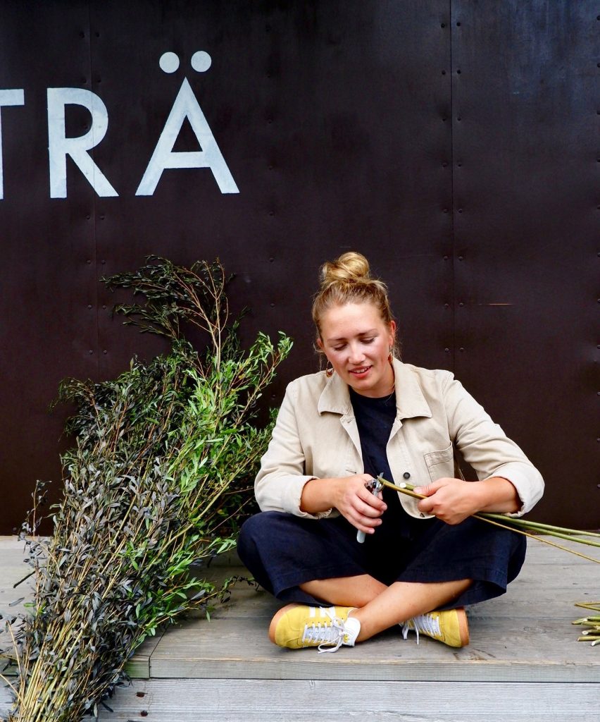 Alice Kettle sitter med benen i kors och flätar pil