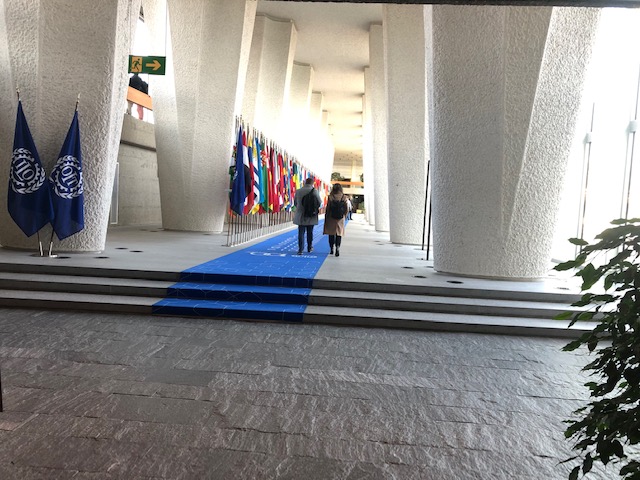 Fotografi på korridor med flaggor och två personer