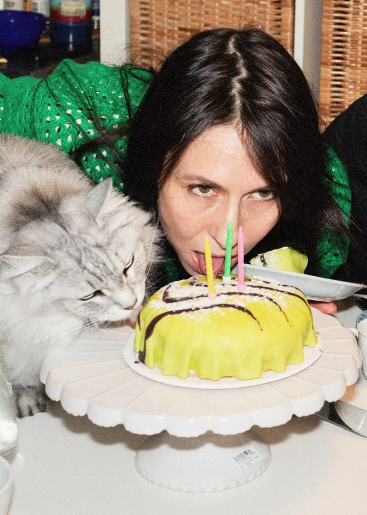 En skådespelare och en katt äter en tårta.