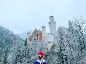Skådespelaren Olle Sarri i filmen står framför ett slott i vinterlandskap.