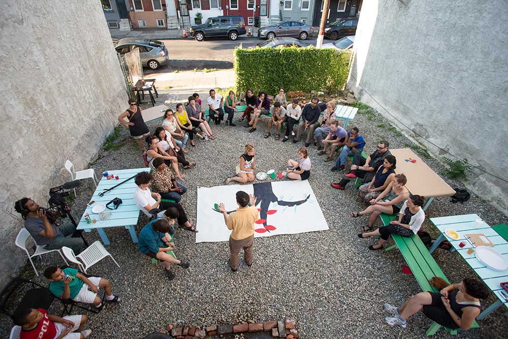 People sitting on the ground between two buildings
