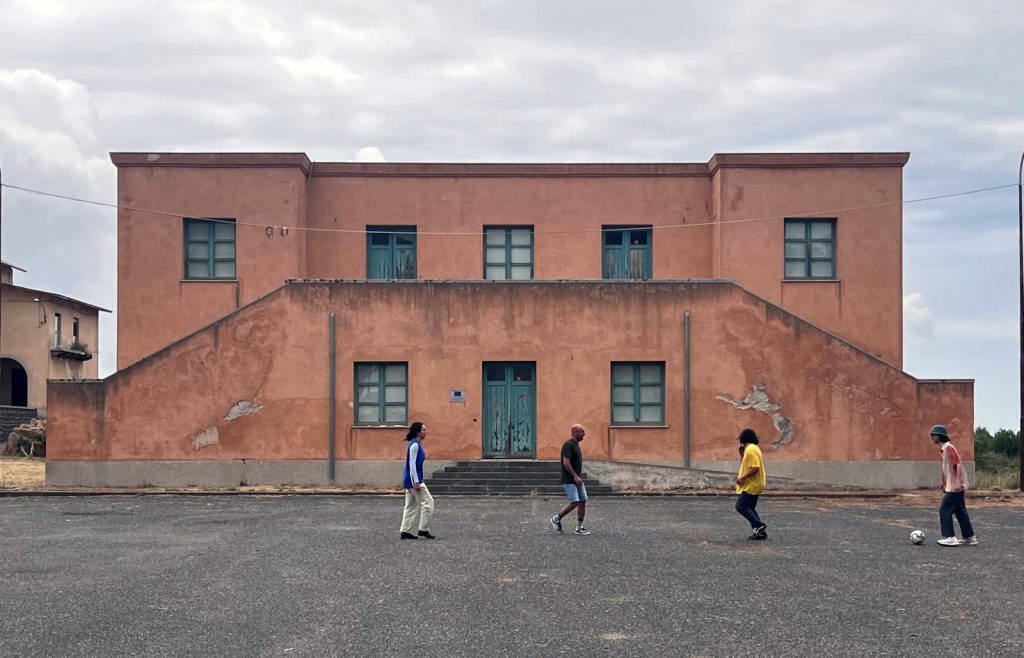 People playing football in front of fascist style building