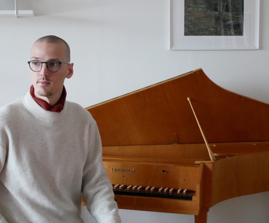Ett foto på en musikkonstnär framför ett piano.