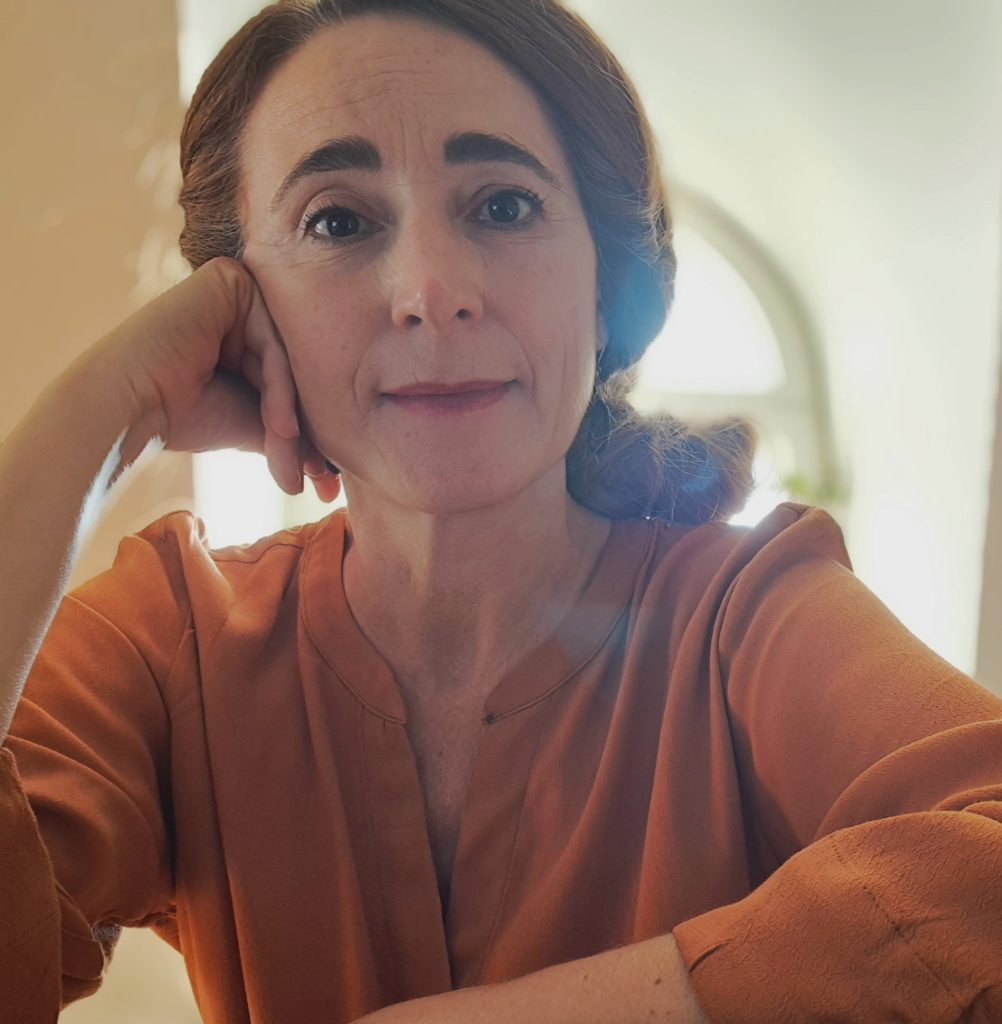 Bildkonstnären Meira Ahmemulic lutar kinden mot handen och tittar rakt in i kameran.