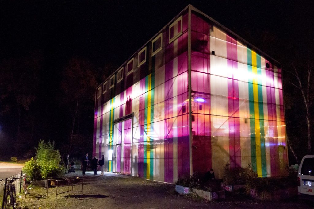 Cyklopens byggnad i mörker med personer stående utanför