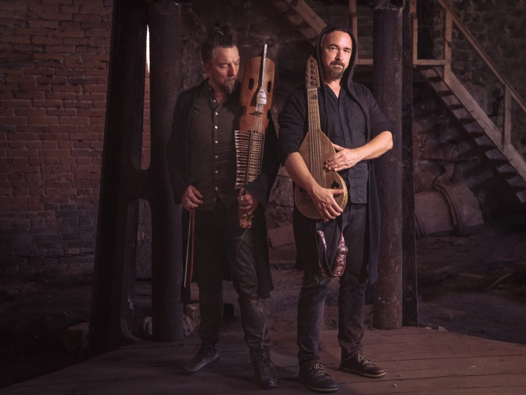 På bild: Duon Pettersson & Fredriksson står och håller sin nyckelharpa och luta i en källarlokal