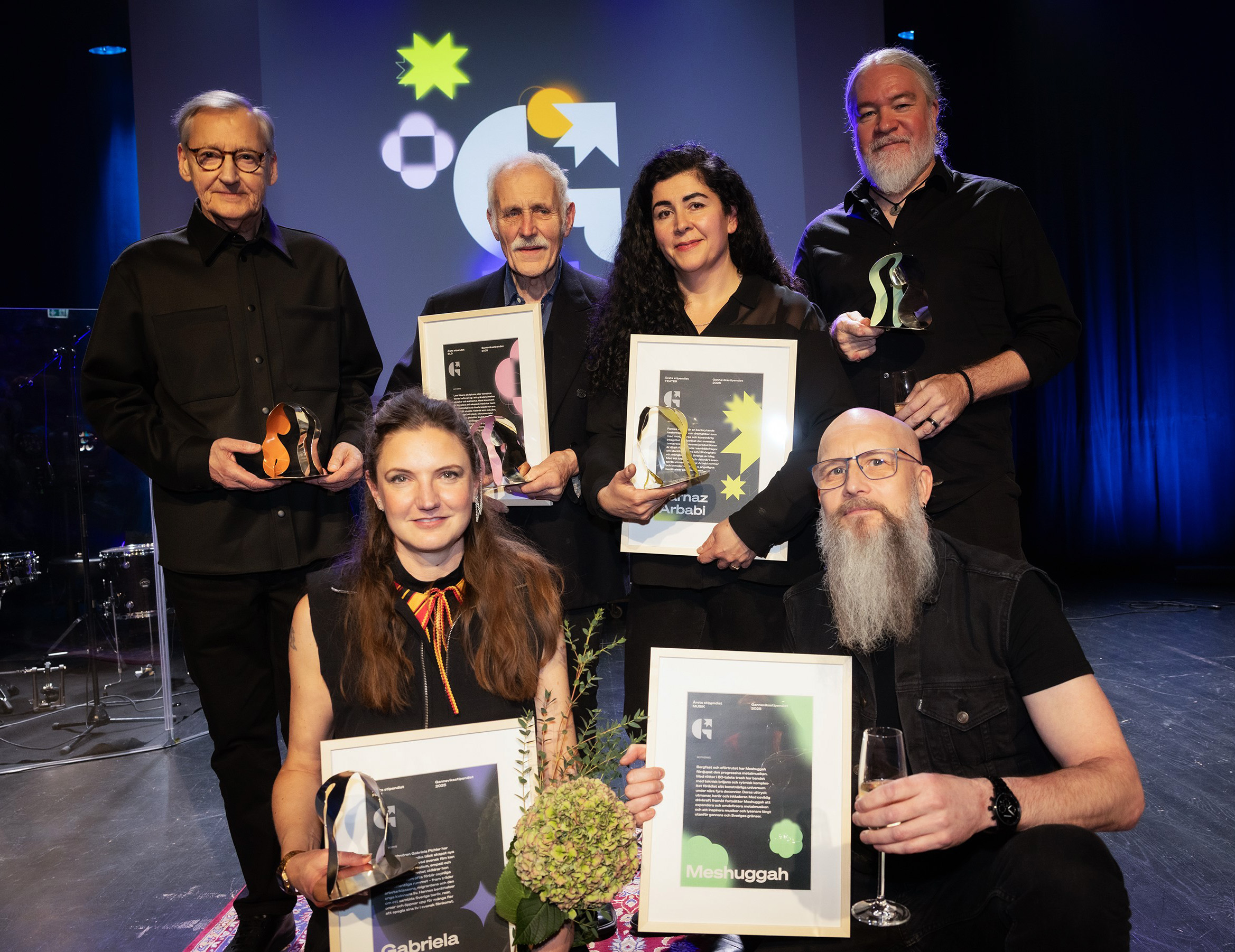 Stipendiaterna håller upp sina diplom och statyetter från Ganneviksutdelningen 2025 på Kulturhuset. Mats Ek var inte med vid bildtillfället. 