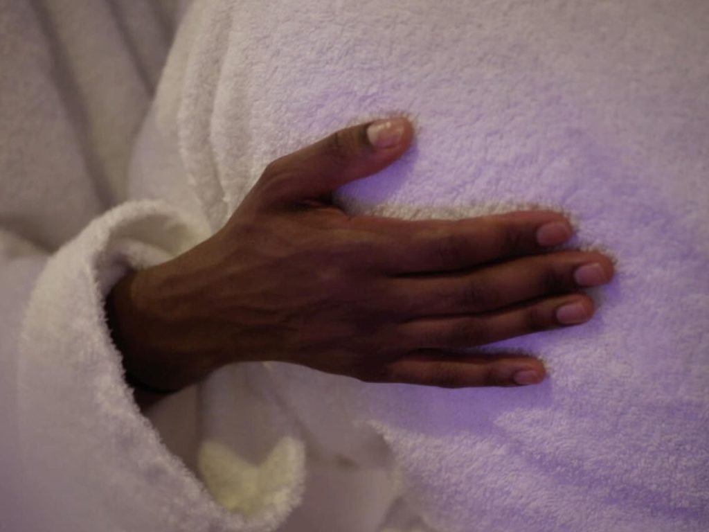 hand on body in white robe