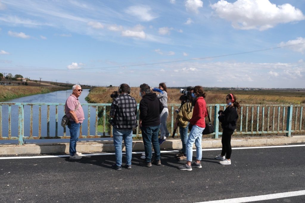 people standing on a bridge over a river