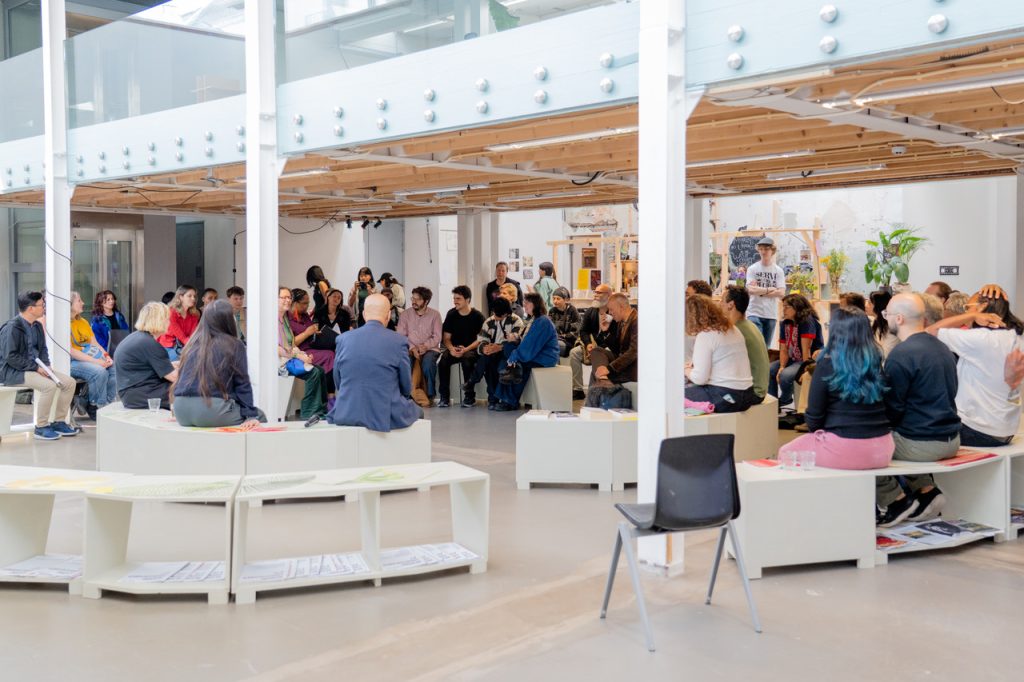 People sitting in a circle in an exhibition space
